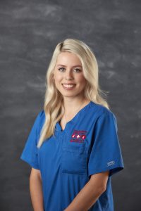 Smiling Portrait image of Caitlin Martin from nursing team wearing blue nurse suit